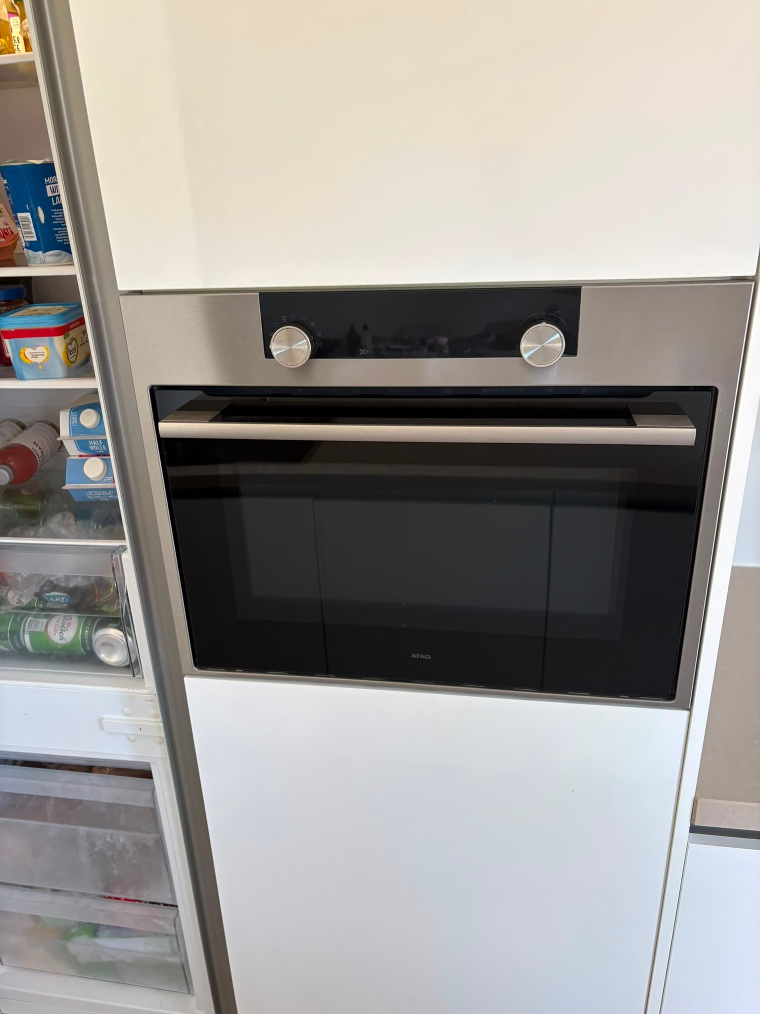Moderne witte hoogglans eilandkeuken met ATAG APPARATEN - Afbeelding 2