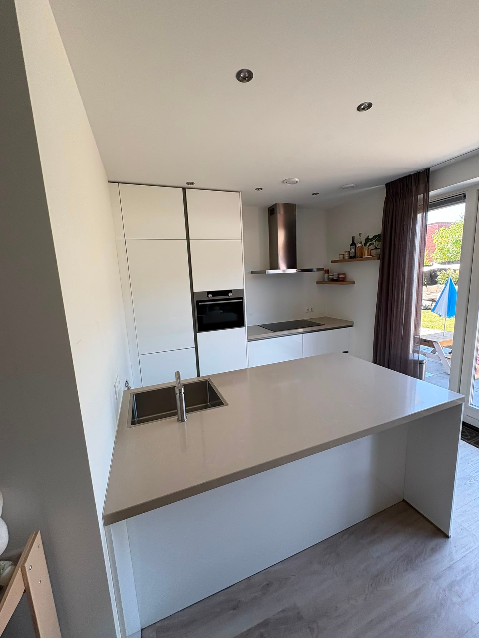 Moderne witte hoogglans eilandkeuken met ATAG APPARATEN - Afbeelding 5
