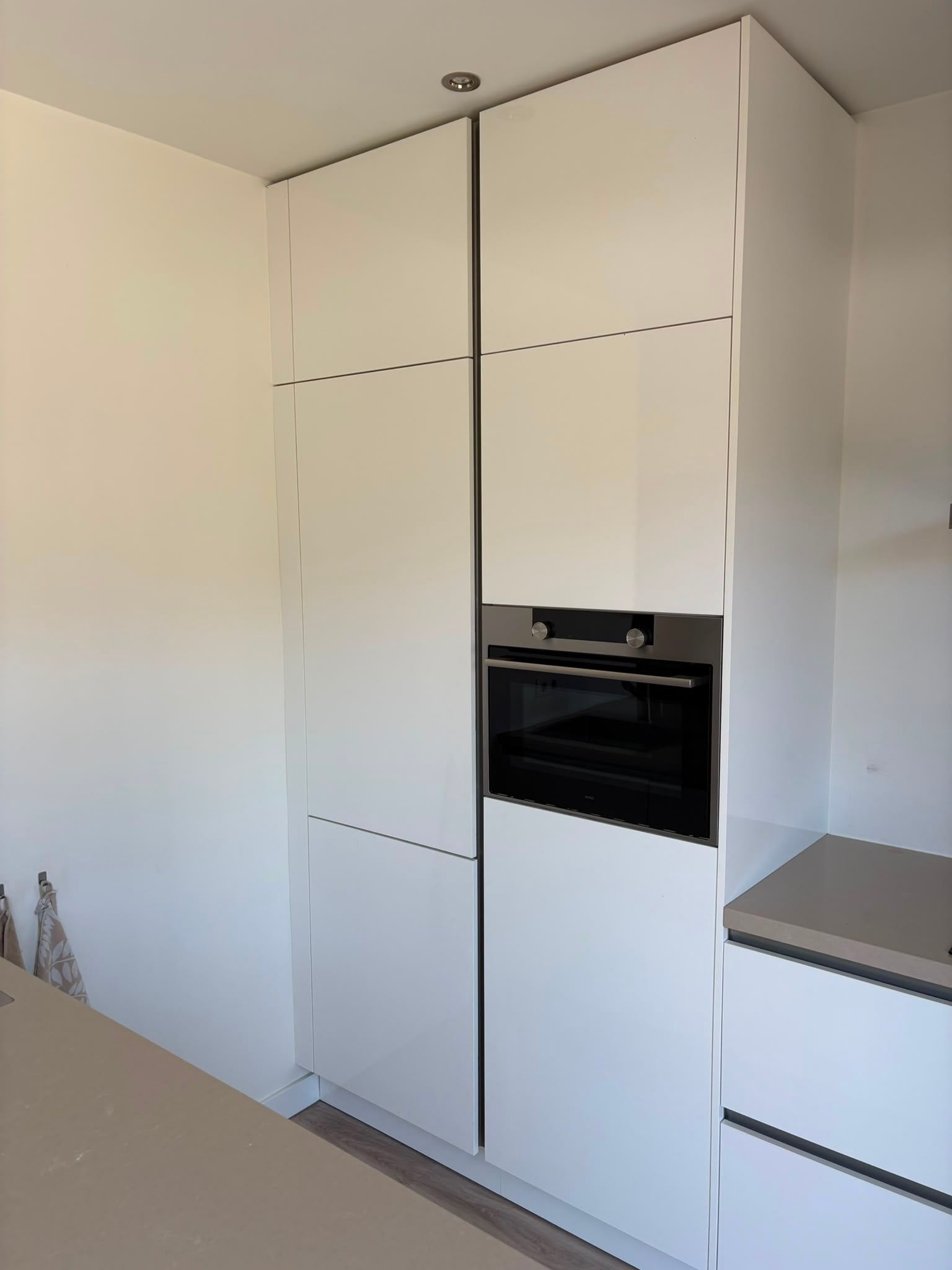 Moderne witte hoogglans eilandkeuken met ATAG APPARATEN - Afbeelding 9