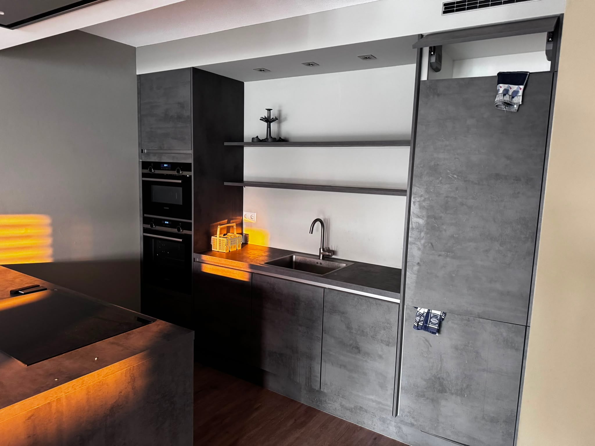 Moderne donkergrijze betonlook eilandkeuken+Siemens apparaten